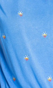 Close up view of the pj salvage sun out pj set. This set is sky blue with tiny embroidered sunsets all over it.