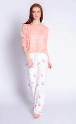 Load image into Gallery viewer, Front full body view of a woman wearing the peach sunset spritzers long sleeve top. This top says hello bubbles, goodbye troubles. On the bottom she is wearing the sunset spritzers pant. The pant is ivory with pink and orange cocktail glasses all over it.

