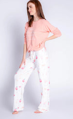 Load image into Gallery viewer, Front, left sided, full body view of a woman wearing the peach sunset spritzers long sleeve top. This top says hello bubbles, goodbye troubles. On the bottom she is wearing the sunset spritzers pant. The pant is ivory with pink and orange cocktail glasses all over it.
