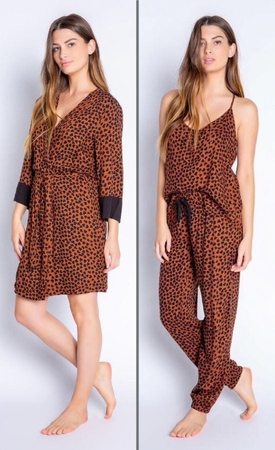 Front full body view of woman wearing the PJ Salvage Wild Love Robe on the left side and the wild robe top and banded pant on the right side. The short, mocha/brown colored robe and top and bottom have a heart shaped animal print all over them. The robe has contrasting black sleeves, and a belt at the waist. The top has thin straps and button detailing in the front. The Banded Pant has a black tie waistband.