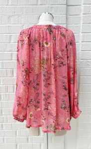 back view of a mannequin wearing the part two erdonae paisley flower blouse. This blouse is bright pink with black and gold paisley floral print on it. The top has long sleeves with cuffs.