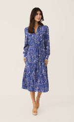 Load image into Gallery viewer, front full body view of a woman wearing the part two true paisley flower dress. This dress is ultramarine/vibrant blue color with white paisley floral print. The dress sits below the knees and has a button down front and tie belt.
