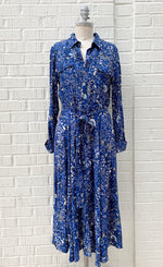 Load image into Gallery viewer, front full body view of a mannequin wearing the part two true paisley flower dress. This dress is ultramarine/vibrant blue color with white paisley floral print. The dress sits below the knees and has a button down front and tie belt.
