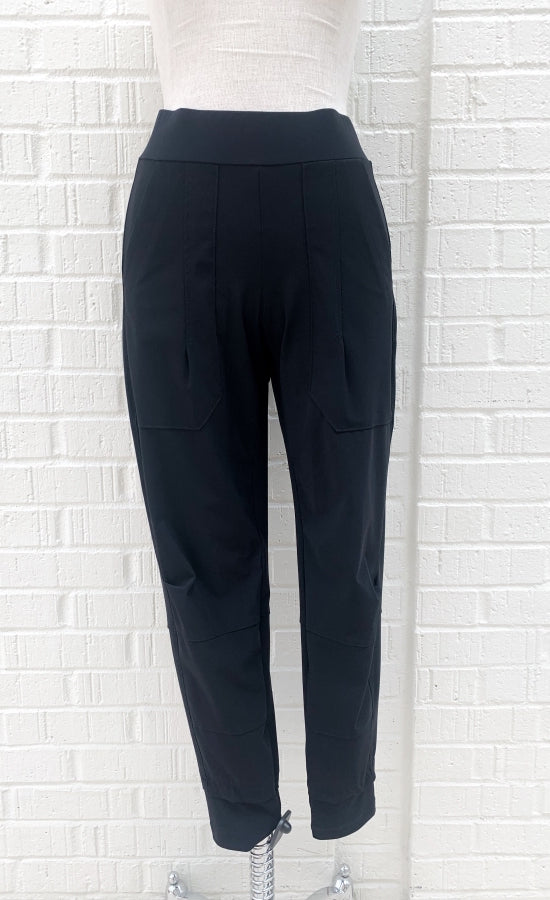 Front view of the porto fan club pant. This black pant is a jogger with large side pockets and a wide waistband.