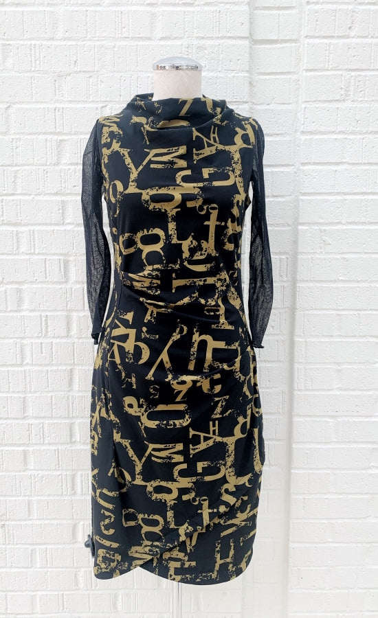 Front view of the porto popstar dress layered over a black mesh tee. This sleeveless dress is black with dijon newspaper letter print. The dress has a fitted silhouette with a draped mock neck.