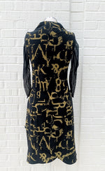 Load image into Gallery viewer, Back view of the porto popstar dress. This sleeveless dress is black with dijon newspaper letter print. The dress has a fitted silhouette with a draped mock neck.
