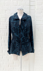 Load image into Gallery viewer, Front view of the porto songbird jacket. This jacket is black with a blue scarab newspaper letter print. The jacket also has a zip up front, a collar, and two front pockets.
