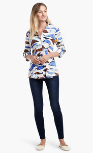 Front full body view of a woman wearing the Nic+Zoe In A Row Blouse. This blouse has a multi shaded blue and brown shibori print, 3/4 length sleeves, a button down front, and a front tie at the waist