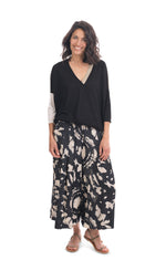 Load image into Gallery viewer, Front full body view of a woman wearing the alembika speckle mandala wide pant and the alembika black multi colorblock top. This top has a beige back, beige right sleeve, beige trim on the left side of the v-neck and a beige back. The front of the top and left sleeve are black. The top has drop shoulder 3/4 length sleeves.
