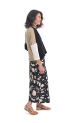 Load image into Gallery viewer, Right side full body view of a woman wearing the alembika speckle mandala wide pant and the alembika black multi colorblock top. This top has a beige back, beige right sleeve, beige trim on the left side of the v-neck and a beige back. The front of the top and left sleeve are black. The top has drop shoulder 3/4 length sleeves.
