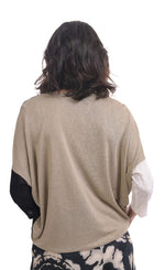 Load image into Gallery viewer, Back top half view of a woman wearing the alembika speckle mandala wide pant and the alembika black multi colorblock top. This top has a beige back, white right sleeve, and black left sleeve. 
