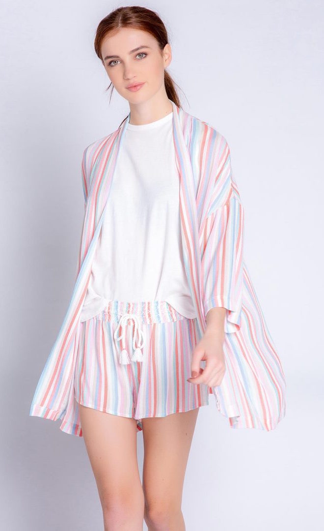 Front full body view of a woman wearing the pj salvage saturday morning stripe jacket. This jacket has multicolored stripes, a draped open front, and 3/4 length drop shoulder sleeves. on the bottom the model is wearing matching shorts.