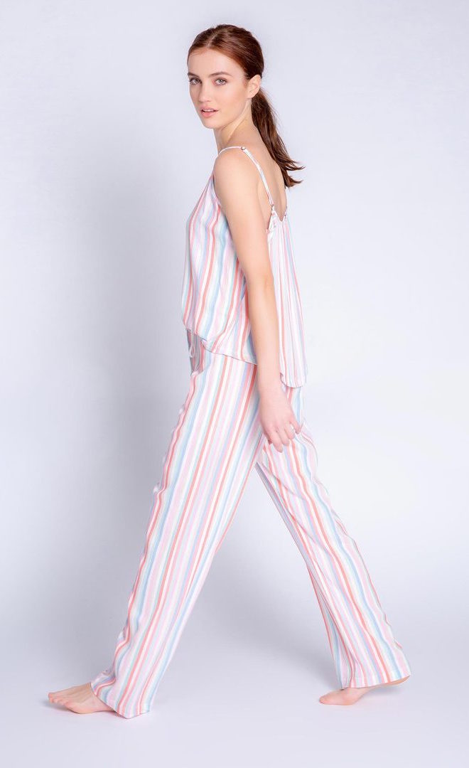 Left side full body view of a woman wearing the saturday morning stripe set. This set includes the saturday morning stripe tank and the saturday morning stripe pant. This pj set is multicolored striped.