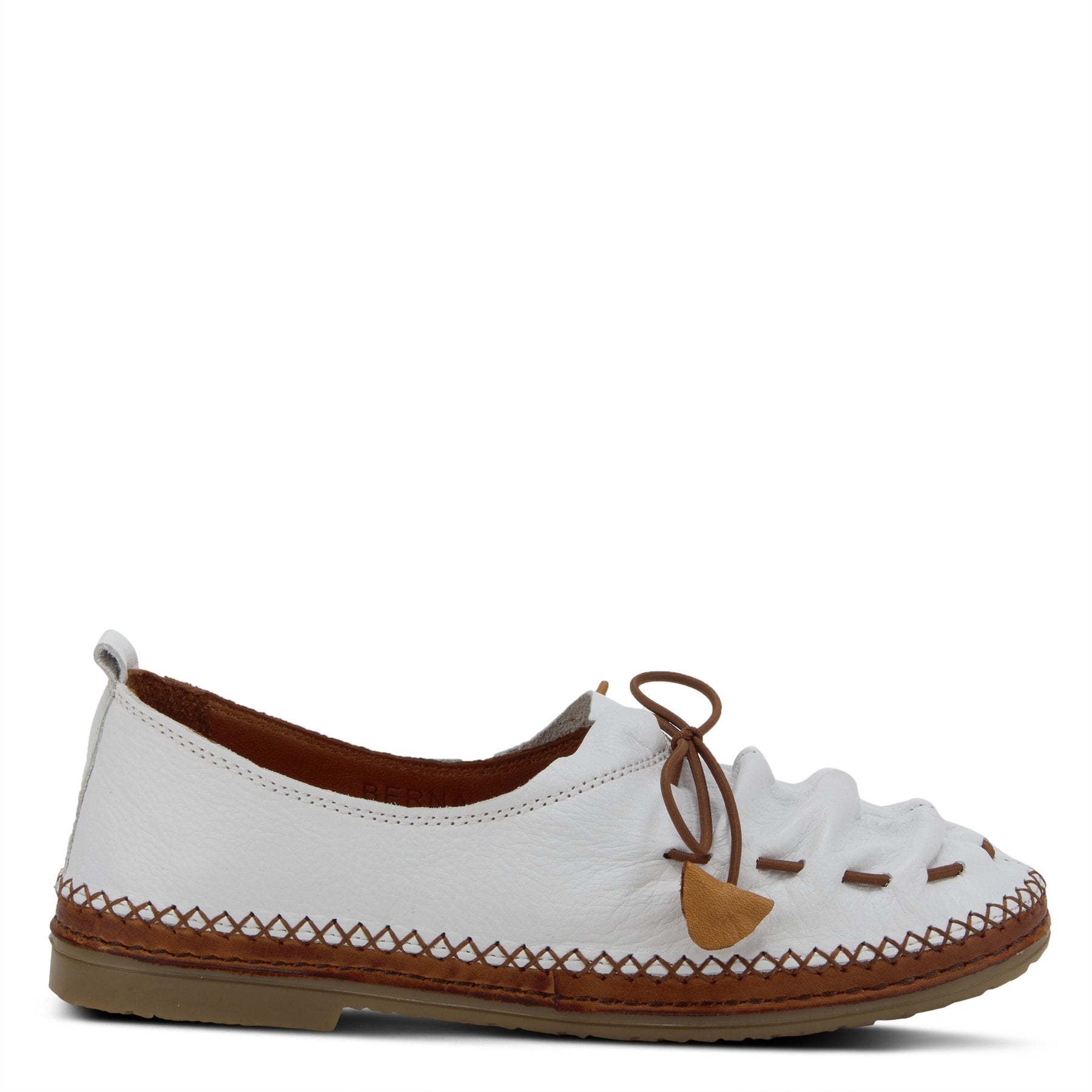 Outer side view of the Spring Step Berna Slip-On Shoe. This closed-toe shoe is flat and white with brown stitching and a brown elastic vamp with a brown tie.