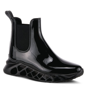 Outer side front view of the yasmine boot. This black boot is rubber with elastic side gores and rubber soles with holes.