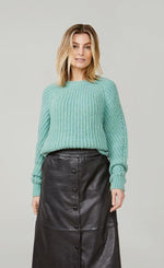 Load image into Gallery viewer, Front top half view of a woman wearing the summum alpaca wool blend sweater in seafoam green. This sweater has long sleeves and a chunky knit appearance. 
