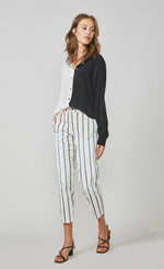 Load image into Gallery viewer, Front full body view of a woman wearing the summum color block blouse. This blouse is black on the left side and ivory on the right side. It has a button up front and long sleeves. On the bottom the model is wearing the summum striped trouser
