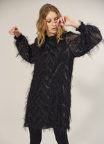 Load image into Gallery viewer, Front full body view of a woman wearing the summum fluffy dress in black. This dress has sparkly fringe on a chevron pattern and ends slightly above the knees.

