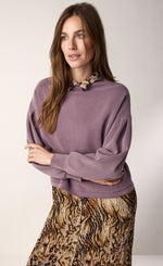 Load image into Gallery viewer, Front top half view of a woman wearing the summum scuba pullover. This pullover is mauve colored, has drop shoulders, long puff sleeves, and cuffs. The top also has a boat neck.
