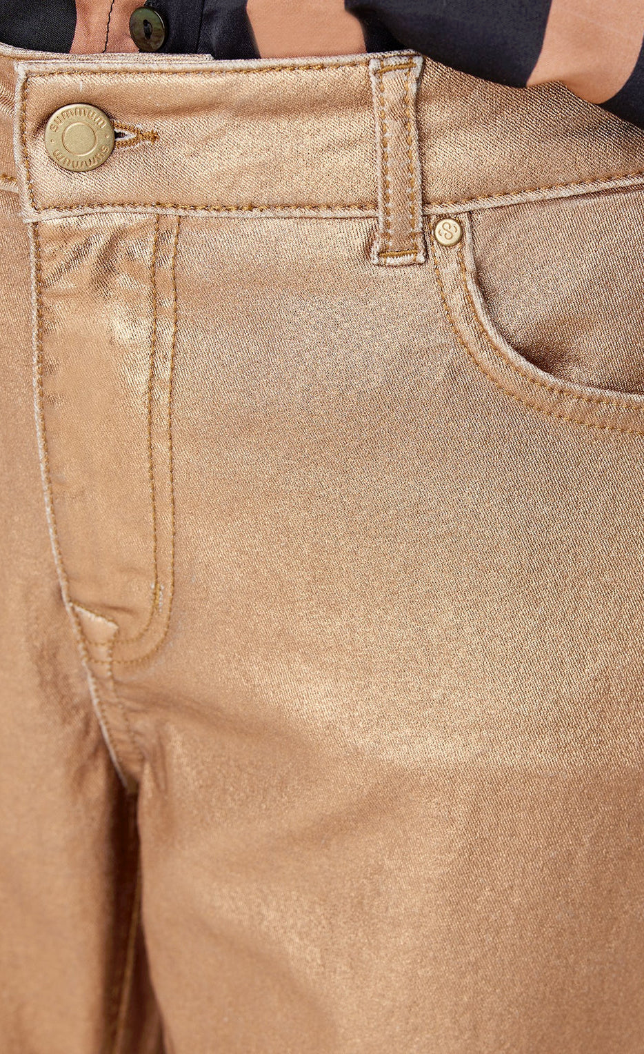Front close up view of a woman wearing the summum skinny foil coated trousers. These trousers are rose gold colored.