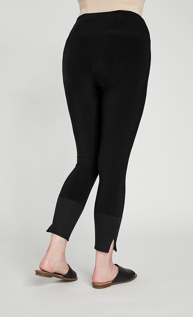 Back bottom half view of the sympli motion trim cuff legging. This legging is black with a ribbed cuff that has a tiny side slit.