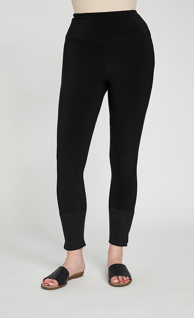 Bottom half front view of the sympli motion trim cuff legging. This legging is black with a ribbed cuff that has a tiny side slit.