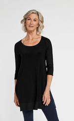 Load image into Gallery viewer, Front top half view of a woman wearing blue leggings and the sympli motion trim raglan tunic in black. This tunic has a scoop neck, 3/4 length ribbed raglan sleeves, a ribbed hem, and long side slits.

