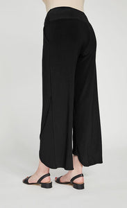Left side, back bottom half view of a woman wearing the sympli narrow rapt pant. These pants are black and feature side pockets, a wide waistband, a wrapped look near the hem, and a relaxed, straight silhouette