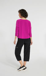 Load image into Gallery viewer, Back full body view of a woman wearing black pants and the Sympli Spark Boxy Top. This top is flamingo colored. It has 3/4 length sleeves and sits slightly above the hips.
