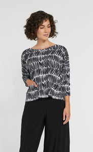 Front top half view of a woman wearing black pants and the Sympli Spark Boxy Top. This top has black and white shifted stripes. It has two front patch pockets, a scoop neck, and 3/4 length sleeves.