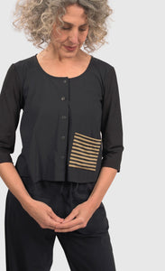 Front top half view of a woman wearing black pants and the alembika tekbika dune crop jacket. This jacket is black with a single left sided front pocket that is striped black and yellow. The jacket has 3/4 length sleeves and a button down front.