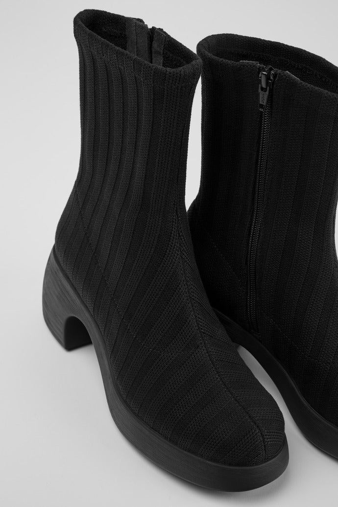 Inner and outer side view of the thelma boot from camper. This sock-boot is black with a platform sole and a curved block heel.