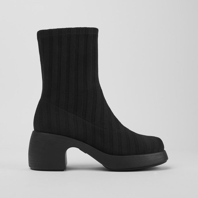 Outer side view of the thelma boot from camper. This sock-boot is black with a platform sole and a curved block heel.
