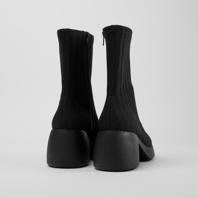 Back view of the thelma boot from camper. This sock-boot is black with a platform sole and a curved block heel.