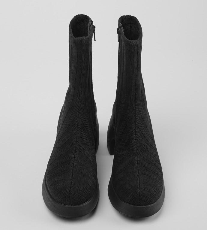 Front view of the thelma boot from camper. This sock-boot is black with a platform sole and a curved block heel.