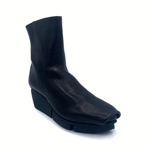 Outer side front view of the trippen flaw boot in black waw.  The boot has a black wedged sole.