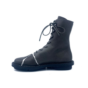 Inner side view of the trippen kintsugi ankle boot. This boot is in the color shark with cracked silver seams on the front. It is flat with a lace up front.