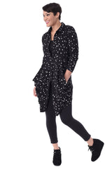 Load image into Gallery viewer, Front full body view of a woman wearing the tulip macy raindrop jacket. This jacket is black with white raindrops all over it. The sleeves are long and the top has a button down front with two draped pocket panels on each side.
