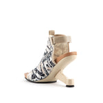 Load image into Gallery viewer, inner back side view of the united nude eamz fab. this high heel sandal has a beige/natural colored plastic upper with black and white geometric patterns. The high heel sandal also has a floating heel and a back strap.
