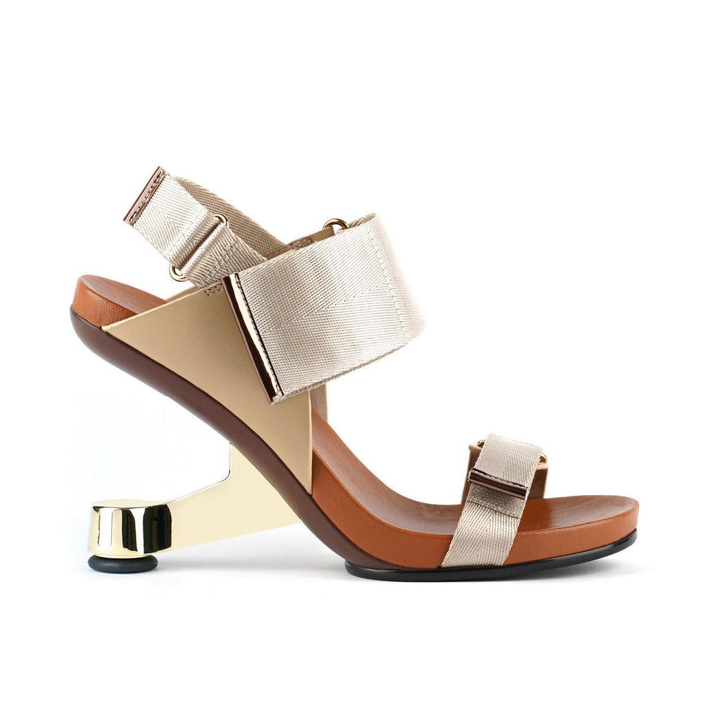 Outer view of the united nude eamz run. This toffee/nude high heel sandal has a chrome door-stopper like heel and 3 adjustable straps.