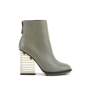 Outer side view of the united nude hi rise bootie. This bootie is grey with a glass like see-through, block shaped high heel. The bootie is an ankle bootie with a back zipper.