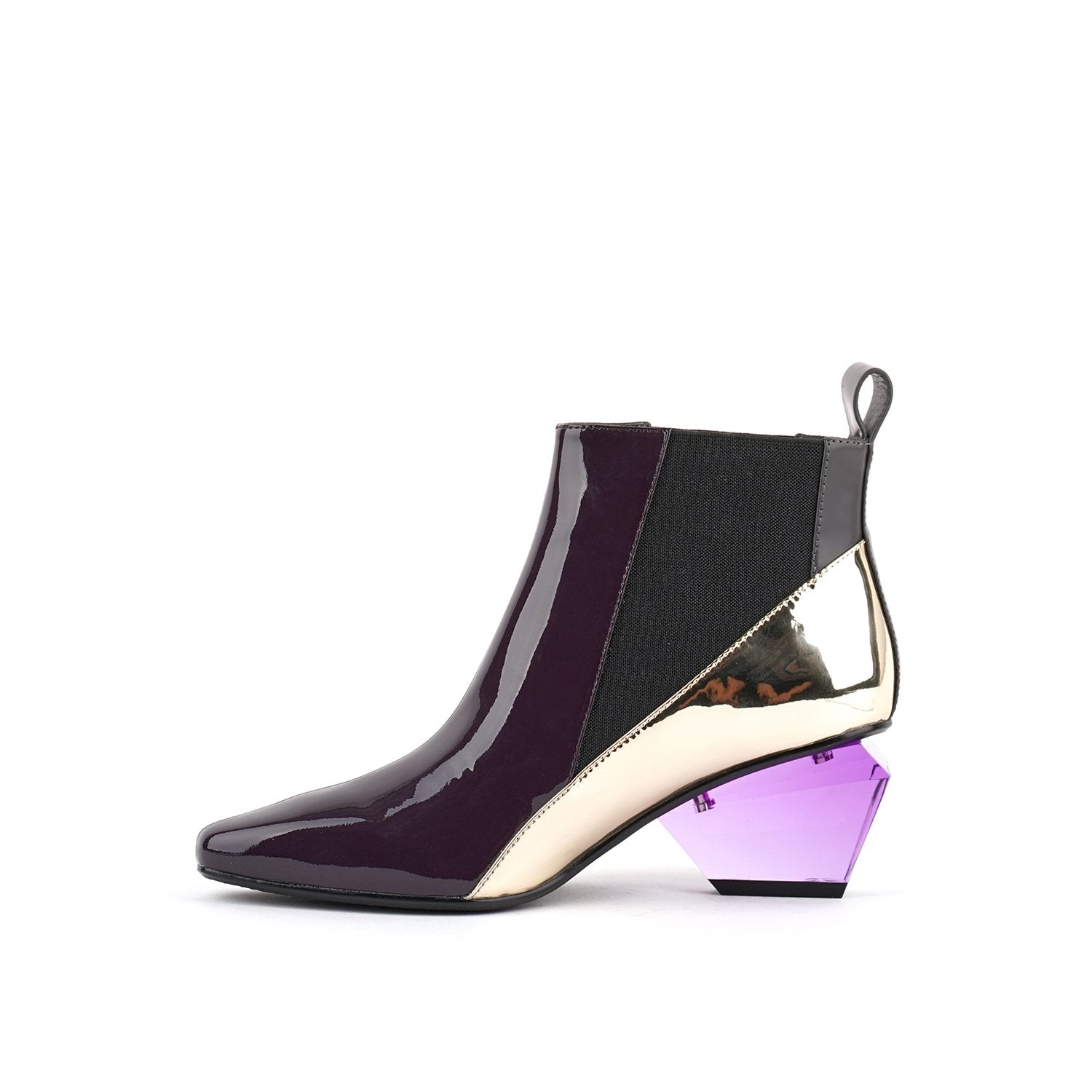 Inner side view of the united nude jacky h bootie. This bootie sits at the ankles. The top of the shoe is midnight brown. The bottom part of the shoe is silver. This bootie has elastic sides and a purple glass like heel.