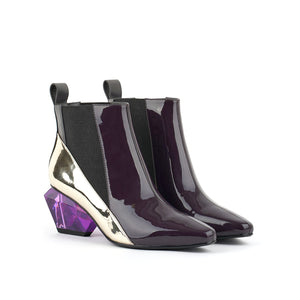 Front outer and inner side view of a pair of the united nude jacky h bootie. This bootie sits at the ankles. The top of the shoe is midnight brown. The bottom part of the shoe is silver. This bootie has elastic sides and a purple glass like heel.