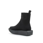 Load image into Gallery viewer, Inner back side view of the united nude wa bootie lo. This bootie is black and minimal. It has a sock-like appearance with a black platform sole.
