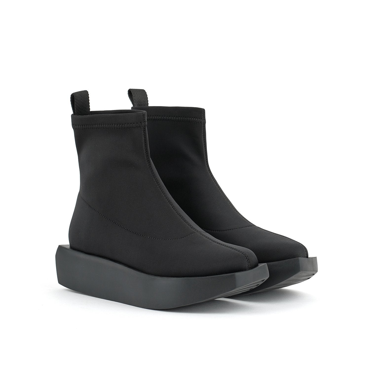 Outer front side view of a pair of the united nude wa bootie lo. This bootie is black and minimal. It has a sock-like appearance with a black platform sole.