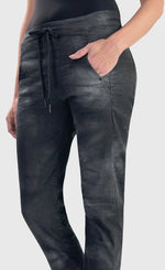 Load image into Gallery viewer, Front bottom half close up view of the alembika urban smoke iconic stretch jeans. These jeans have a relaxed slim fit and a drawstring tie waistband. The pant has a washed grey print and two front side pockets.
