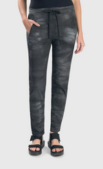 Load image into Gallery viewer, Front bottom half view of the alembika urban smoke iconic stretch jeans. These jeans have a relaxed slim fit and a drawstring tie waistband. The pant has a washed grey print and two front side pockets.

