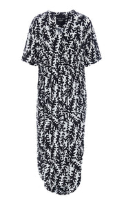 Front view of the Bitte Kai Rand Graphic Leaves Long Dress. This dress features a black and white leaf print all over it. It has short sleeves, a v-neck, and a rounded hem.