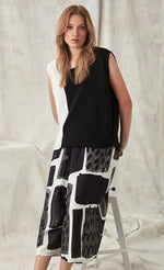 Load image into Gallery viewer, Front full body view of a woman wearing a black and white top with the crea concept black and white print pant. This pant has an abstract print on it, and a wide leg.

