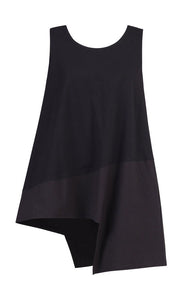 Front view of the Alembika black cotton asymmetrical tank. This sleeveless tank has a stepped hem with two different black fabrics.  